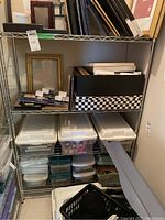 Full view of metal wire utility shelving unit loaded with various plastic bins, framed pictures, and boxes demonstrating size and shelving style.