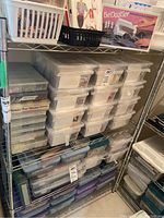 Full view of four-tier metal wire shelving unit stocked with plastic storage boxes and containers.