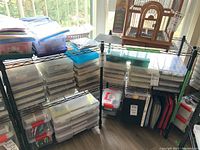 Front view of two black metal utility shelves stocked with various plastic containers and items (not included in sale).