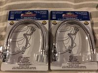 Two unopened 12-inch toilet hookup kits side by side showing the front packaging, featuring the chrome-plated flexible hose and easy installation instructions.