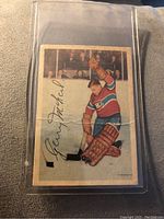 Front of 1953-54 Parkhurst Gerry McNeil hockey card showing player in goalie gear with autograph printed and visible wear including crease.