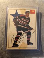 Front side of the 1954-55 Bill Gadsby Parkhurst hockey card showing player in Chicago Black Hawks uniform with captain's C, card number 87.