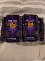 Five 3M sanding blocks in original packaging, each labeled 220 grit and made for dust channeling, shown against a striped background.