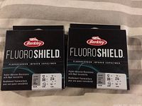 Two boxes of Berkley Fluoroshield fishing line, each labeled 12lb test, 300 yards, clear color.