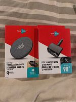 Photo of two boxed products: a Blue Hive Qi fast wireless charger and a Blue Hive 12V socket with two USB ports.