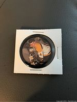 Front side of coin showing Bobby Orr in Boston Bruins uniform with hockey stick.