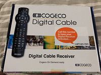 Cogeco Digital Cable receiver box original packaging with remote control graphic and activation phone number.