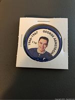 Front side of coin showing color image of George Armstrong and season info