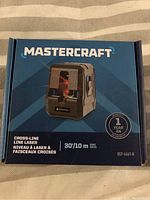 Front image of the MasterCraft Cross-Line Laser box showing the device image, brand, and main features including range and warranty.