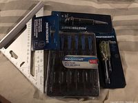 Full lot showing aluminium rafter square, needle file set, center punch, and mini screwdrivers in original packaging