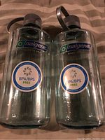 Two clear Nalgene water bottles side by side, showing manufacturer label and BPA/BPS free sticker.