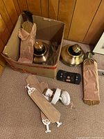 Box with fan blades, motor housings, light sockets, remote control, and mounting hardware visible.