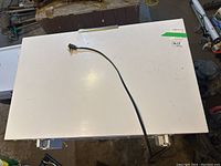 Top view of white chest freezer with attached electrical cord and two latches visible on front edge of lid