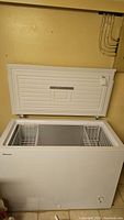 Chest freezer with lid open showing interior and two baskets
