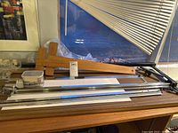 Photo of mat cutter showing wooden base, metal rails, and cutting lever handle.