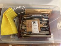 Overhead view of plastic container with envelopes and postcards labeled 'Postcards + Stamps'