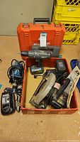 Photo showing entire lot of power tools in an open box and accompanying cases.