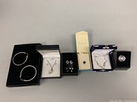 Overview photo showing all 6 pieces including 2 necklaces, hoop earrings, ring, pendant with matching studs, and choker.