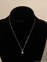 Full view of the 9K gold choker necklace displayed on black velvet bust showing thin chain and small pendant.