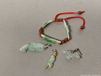 Full view of the jade bracelet with wooden beads and three jade pendants arranged flat