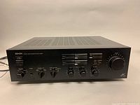 Front view of the black Denon PMA-500V precision audio component amplifier showing power switch, speaker selector knob, headphone jack, monitor/copy selector, phono selector, and multiple control knobs including volume.