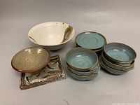 Overview of all pottery items including large bowl, handle soup bowls, saucers, oval bowl and rectangular plate