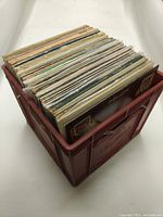 Red plastic crate filled with a large number of 12-inch vinyl records