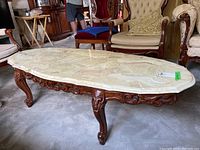 Overall view of coffee table showing marble top and carved wooden base