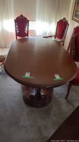 Full view of oval wood dining table with leaf inserted, surrounded by chairs