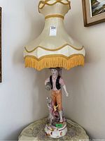 Full view of the large hand-painted ceramic lamp with cream-yellow fabric shade, showing the base and shade.