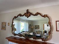 Full front view of large ornate wall mirror above fireplace
