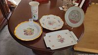 Photo showing all items on table: three platters, display plate on stand, and vase