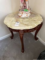 Front view showing overall appearance, marble top and carved wood legs