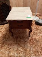 Front view of wooden side table with stone top, showing two decorative drawers and cabriole legs.