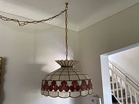 Overall photo showing the entire hanging Capiz shell swag lamp with white and pink circular shell panels suspended by chain.