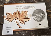 Cardboard packaging with maple leaf artwork and $20 coin image, bilingual text 'Farewell to the penny / Adieu à la pièce de un cent'