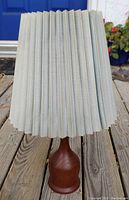 Front view of Mid-Century Modern teak table lamp with the corrugated paper lamp shade showing wear.
