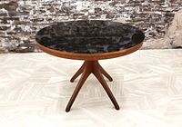 Front view of round dining table showing black Arborite top and sputnik legs