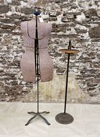 Full photo showing vintage dress form on original metal tripod stand and separate antique cast iron dress form stand with wooden top plate