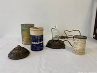 Lamp disassembled showing metal base, glass decorative cylinder pieces, and electric cord.