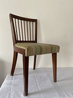 Single chair showing wooden frame with vertical slats on backrest and upholstered seat with striped fabric.