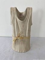 Front view of the ceramic T-shirt vase showing the raffia tie and fabric-like texture.