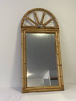 Full view of bamboo horizon mirror with arched top and rectangular reflective surface
