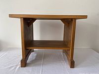 Front view of the wooden side table showing rectangular shape and lower shelf.