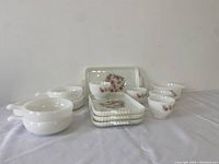 Full view of sandwich trays, cups, and bowls showing milk glass material with floral pattern and beaded edges on trays.