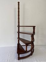 Front view of four-tier solid wood library steps with turned spindles and ball finial