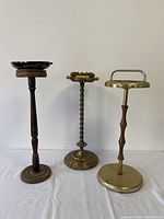 Three standing ashtray stands side by side on white background showing overall condition and height differences.
