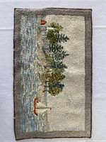Full view of rectangular needlepoint artwork laid flat on white surface