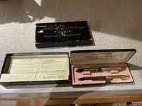 Two vintage black and gold pens in a pink-lined box with original outer black box and paperwork