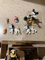 Top view of assorted small Disney figurines and pins on countertop